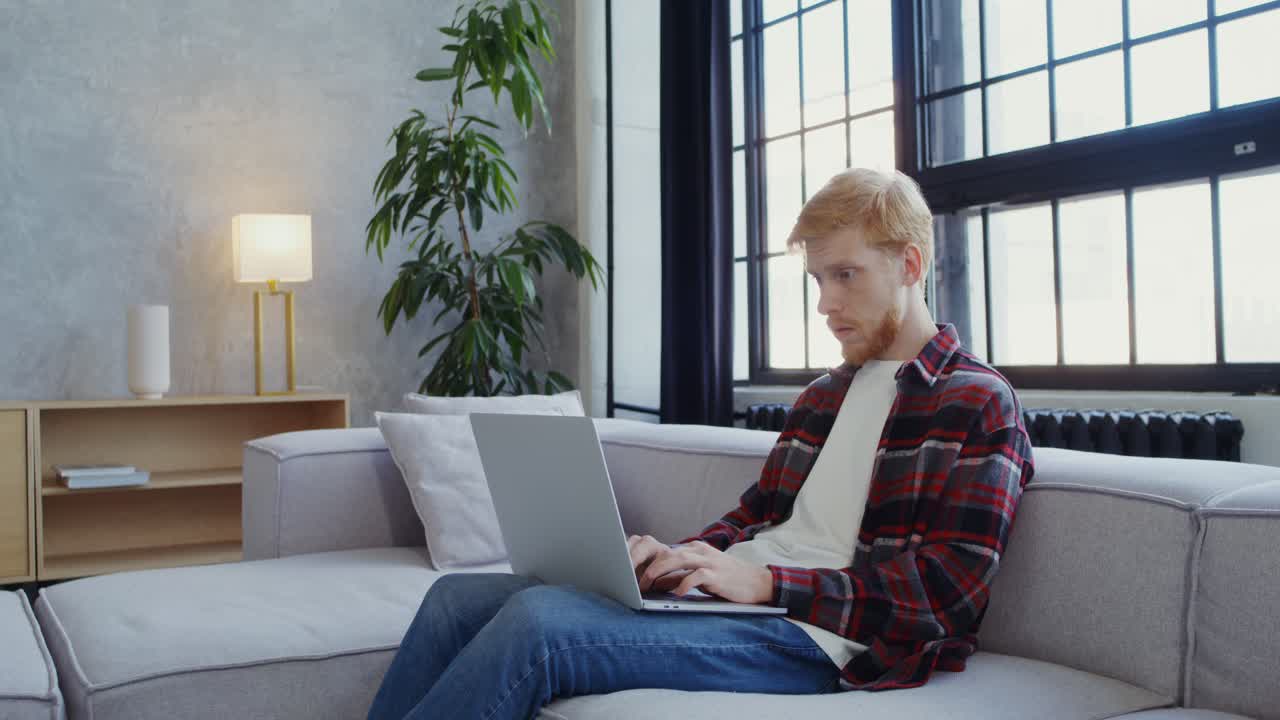 현대적인 거실의 소파에서 노트북으로 일하는 남자