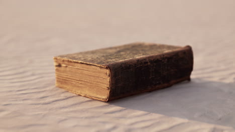 old book on the sand beach