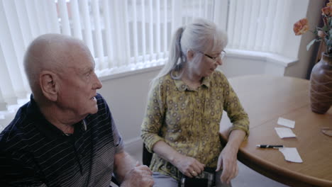 elderly couple at home checking blood pressure