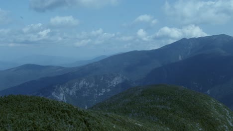 the white mountains of new hampshire beneath a cloudy blue sky as the camera pans