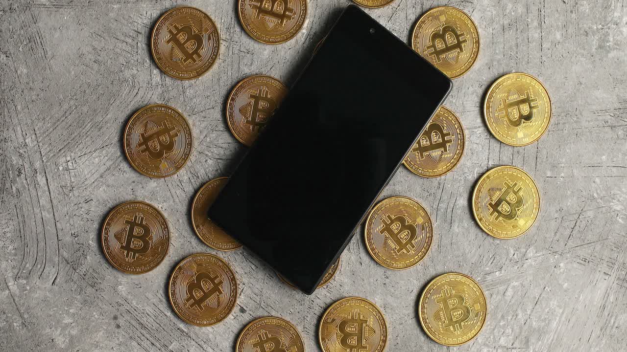 teléfono inteligente y bticoin sobre fondo gris