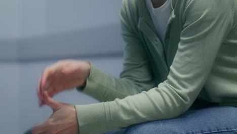 woman sitting and looking down, potentially experiencing anxiety or distress