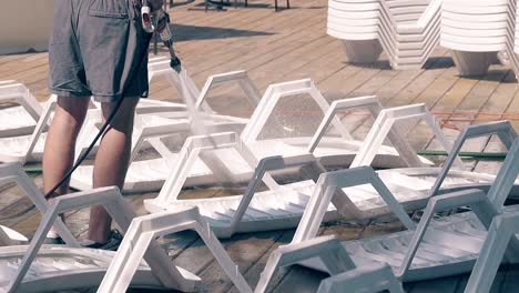 beach worker washes the beach loungers 2