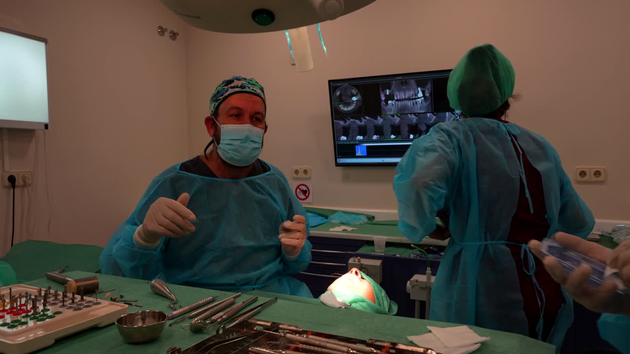 Undecided dentist choosing tools for implant as assistant offers help, 4K