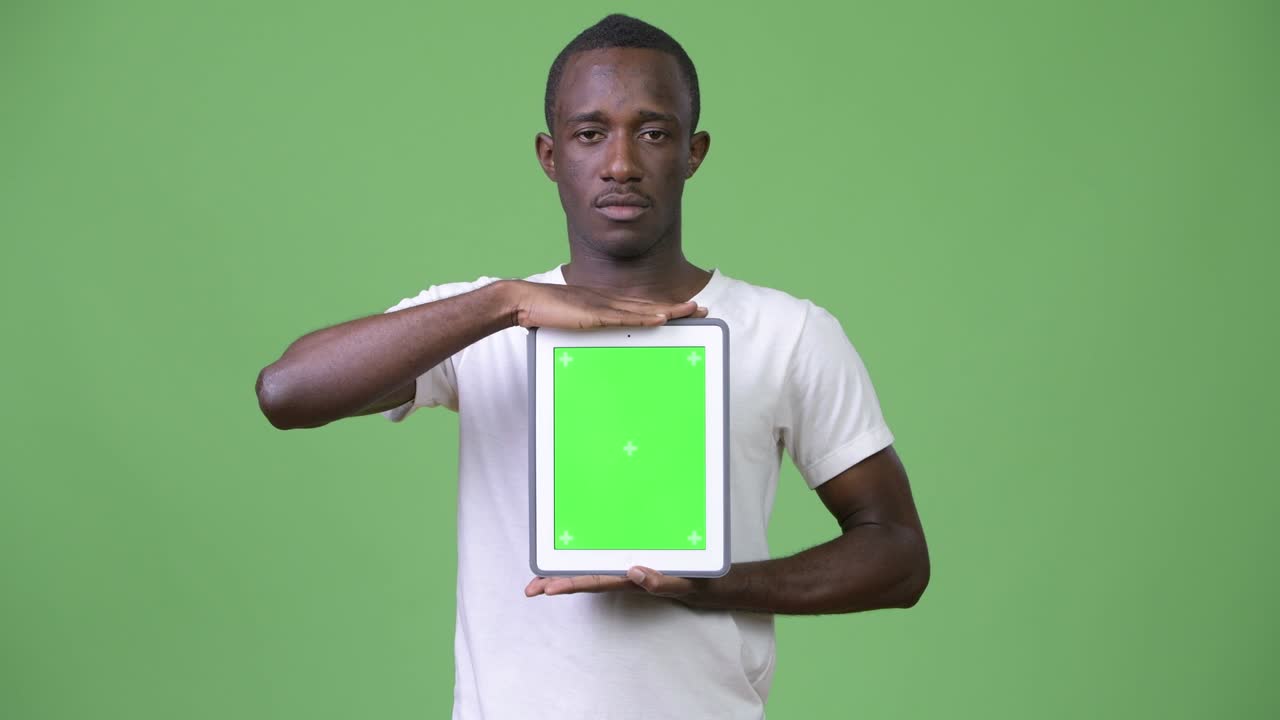 Ung afrikansk mand viser en digital tablet