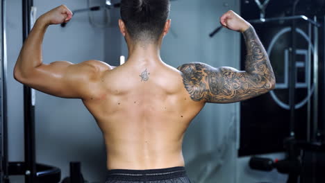close up strong sportsman bodybuilder muscular athlete flexing inflated athletic back muscle fitness exercise. healthy and active lifestyle concept