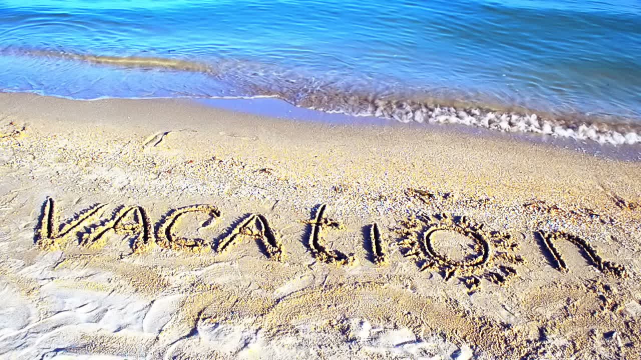 The inscription Vacation on sand. Inscription on sand