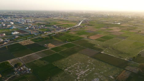 4k: drone flying over agricultural land in the city of punjab, pakistan