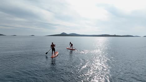 A couple doing paddle surfing on the Adriatic coast.