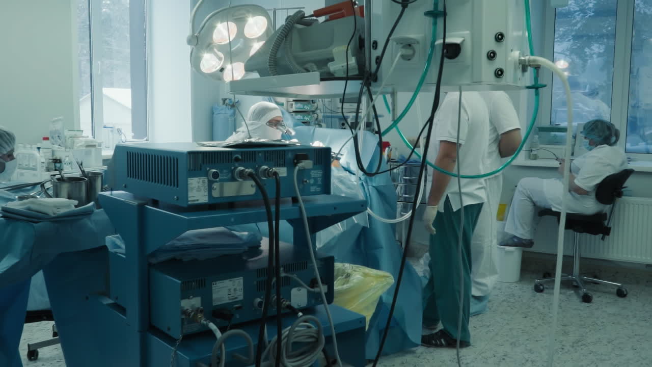Cardiologists team at heart surgery in clinic. Skilled surgeons and assistants conducts coronary artery bypass surgery with modern equipment in hospital