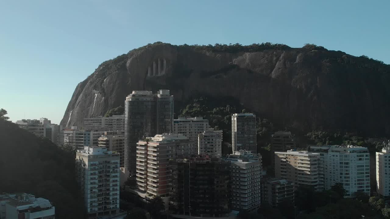 vista aérea de edificios de gran altura con una gran colina rocosa detrás en el barrio de copacabana en río de janeiro en un día brillante con cielo azul