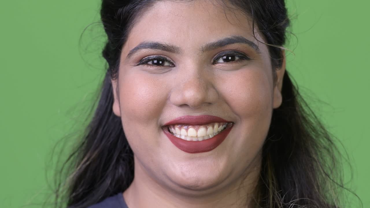 joven sobrepeso hermosa mujer de negocios india contra fondo verde