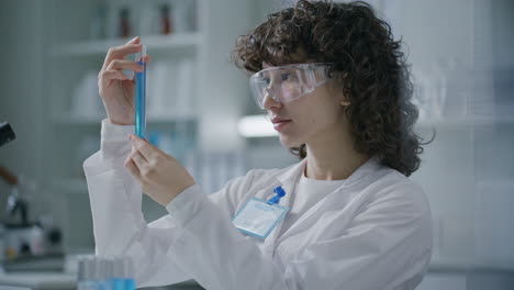 portrait of smiling female scientist holding test tube in laboratory