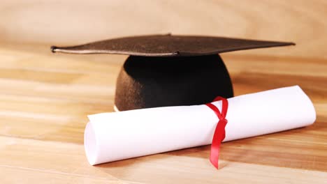 Close-up-of-graduation-certificate-with-mortar-board