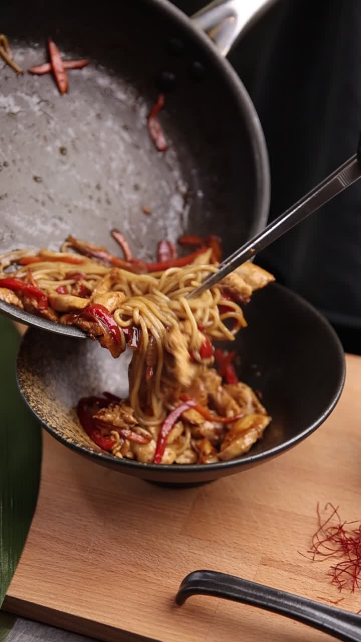 Servire deliziosi noodles asiatici saltati con pollo e verdure