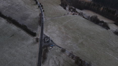 Flying-over-a-path-overlooking-the-surrounding-countryside-during-a-light-beginning-snowfall