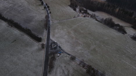 volando sobre un camino con vistas al campo circundante durante una ligera nevada que comienza