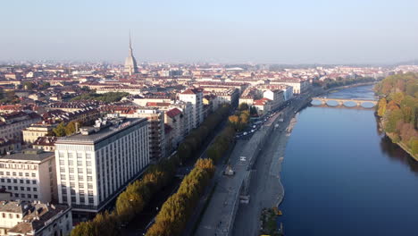 aerial reveal turin city and mole antonelliana next to river po, fall