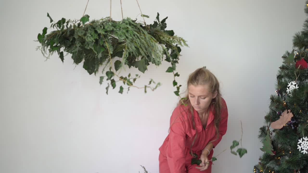 오버을 입은 여성 꽃가루가 꽃받침을 만니다. 크리스마스 준비 개념...