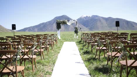 lugar de boda vacío en el prado al aire libre con montañas en segundo plano.