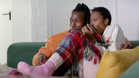 Afroamerikanisches-Paar-Entspannt-Beim-Fernsehen-Mit-Popcorn-Zu-Hause,-Zeitlupe