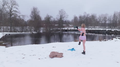 disparo cómico de una mujer bañadora de hielo saltando y moviéndose para calentarse después de su inmersión