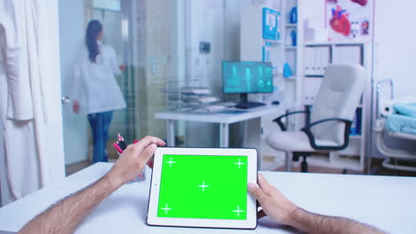 Pov-shot-of-medic-tapping-on-tablet-pc-with-green-screen