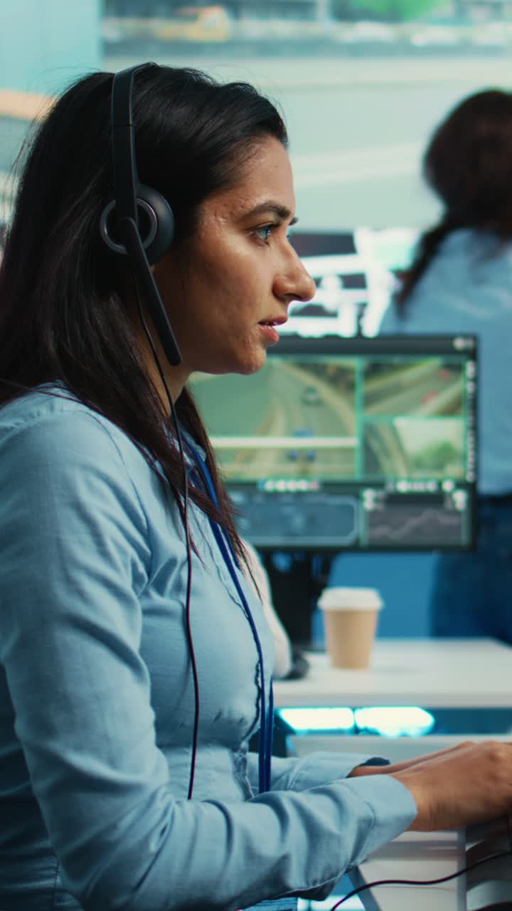 Woman Working on Computer and Talking on Headset in Control Room