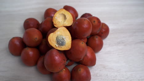 close up: pile of chontaduro fruits with pit inside - fruit tasted like a raw sweet potato