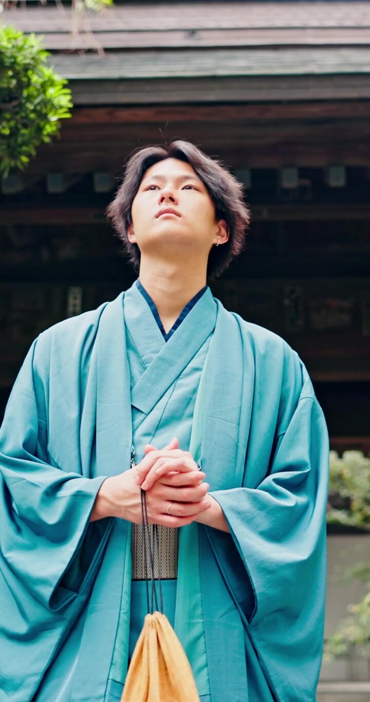Giovane uomo giapponese in kimono tradizionale in piedi presso un tempio