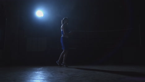 hermosa mujer boxeadora en entrenamiento en el pasillo saltando la cuerda