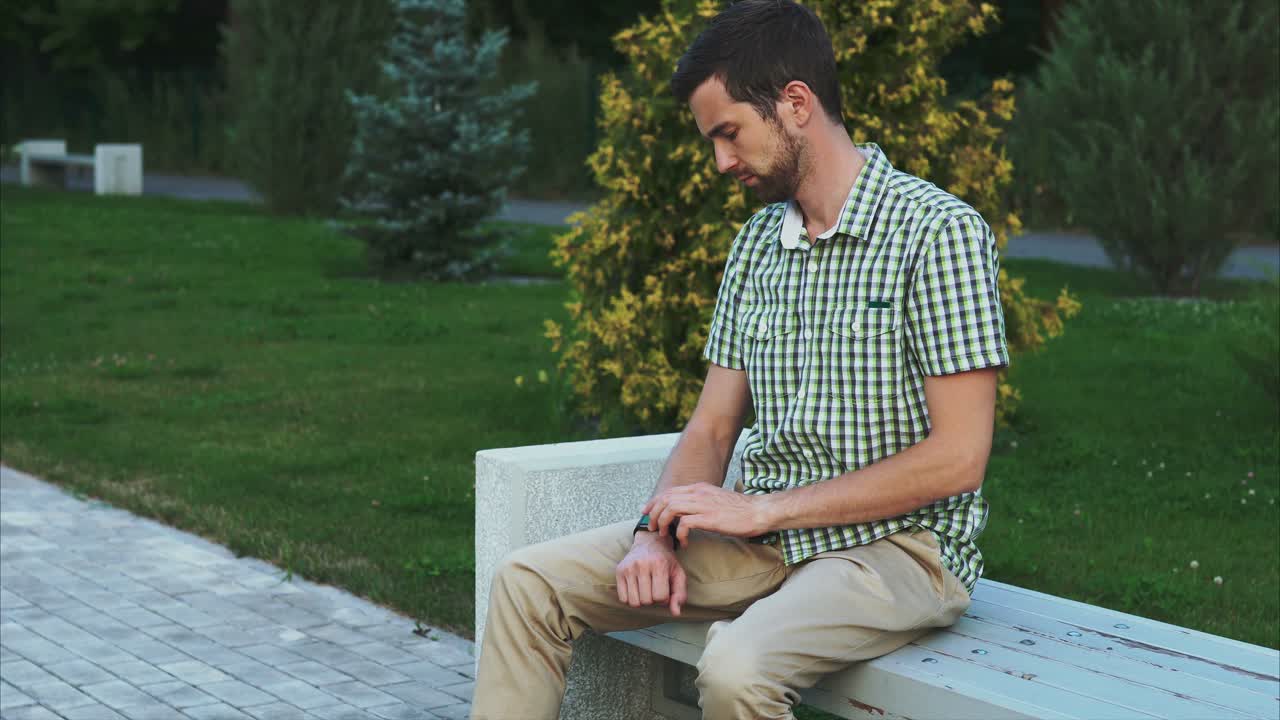 Hombre revisando su smartwatch en un parque