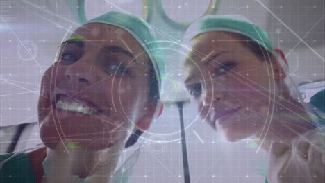 Animation-of-network-and-data-processing-over-smiling-caucasian-female-surgeons-in-operating-theatre