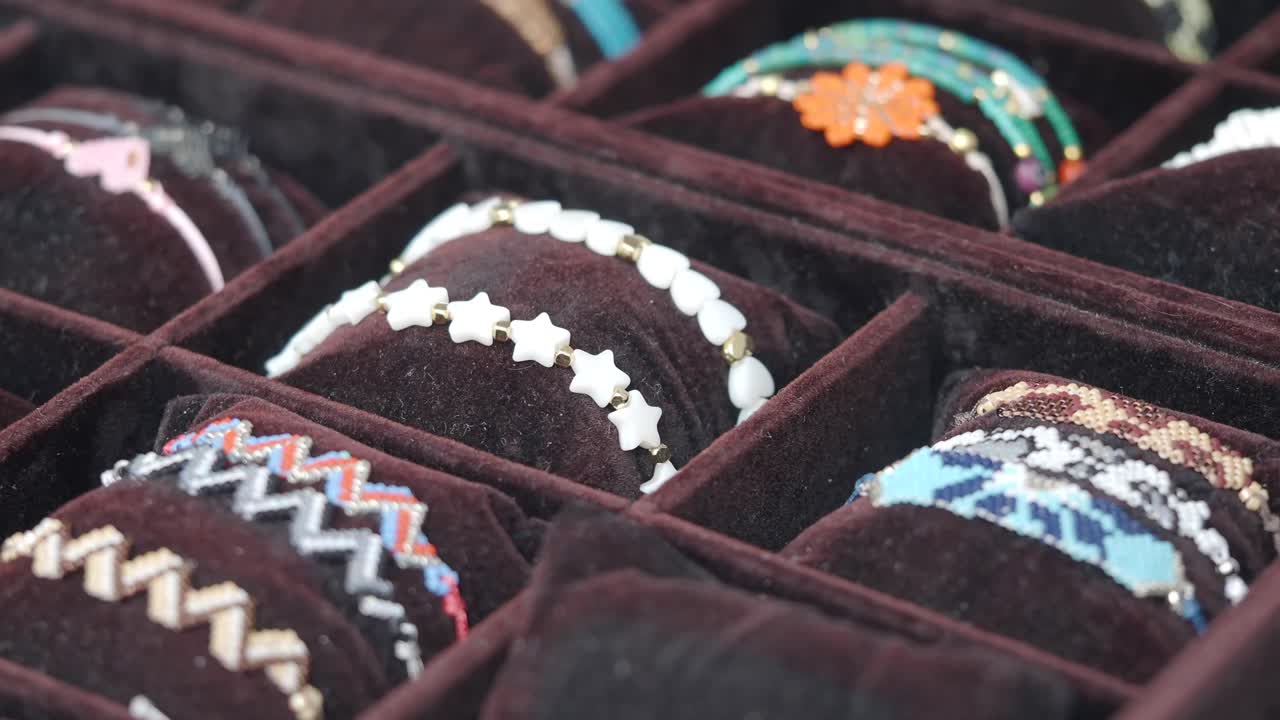 Primo piano di braccialetti colorati fatti a mano esposti in un portagioie di velluto
