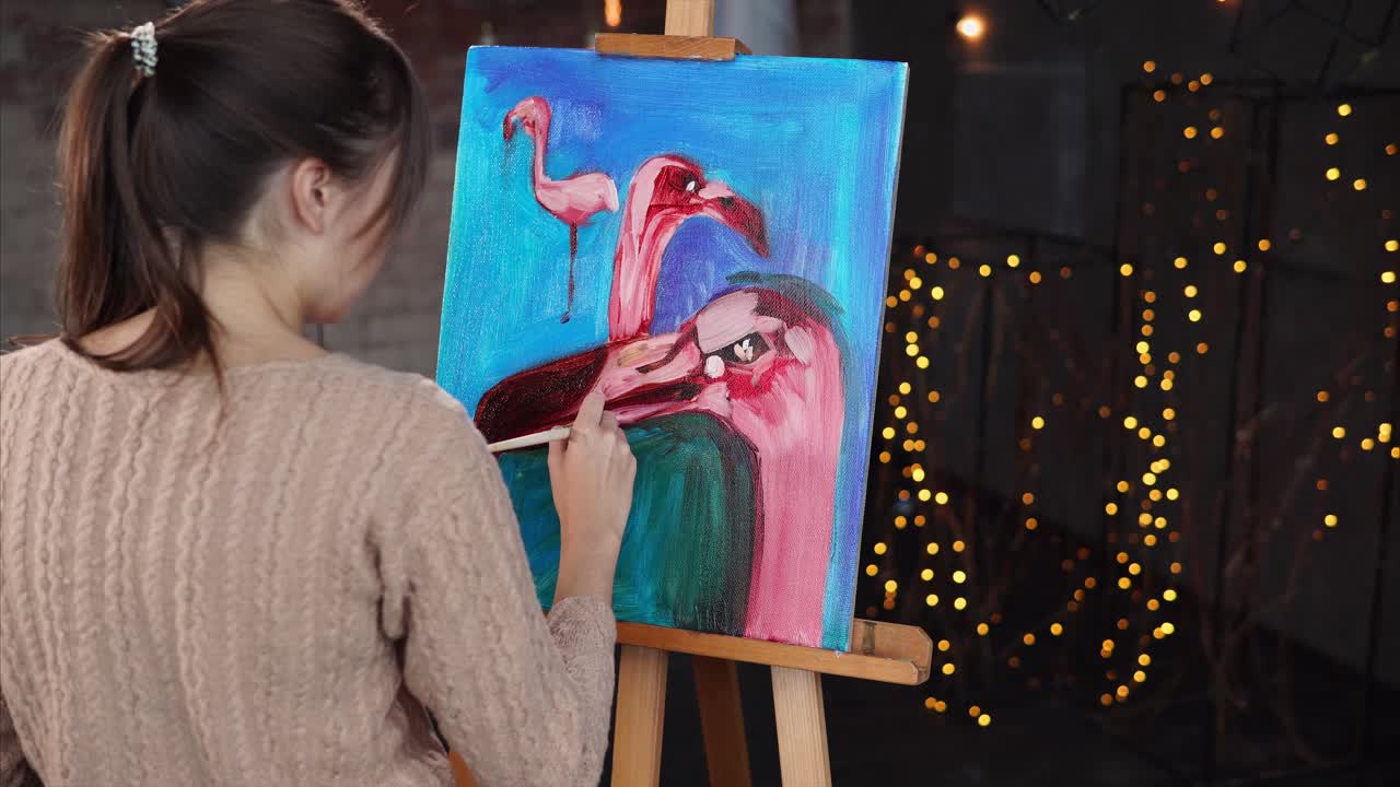 Woman painting flamingos on canvas