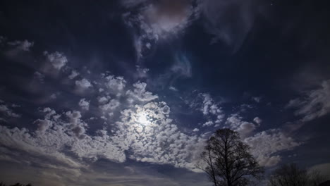 night timelapse of some clouds with the moon behind.