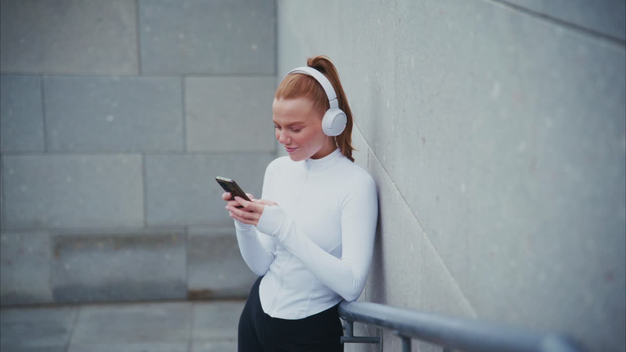 Woman with headphones using phone