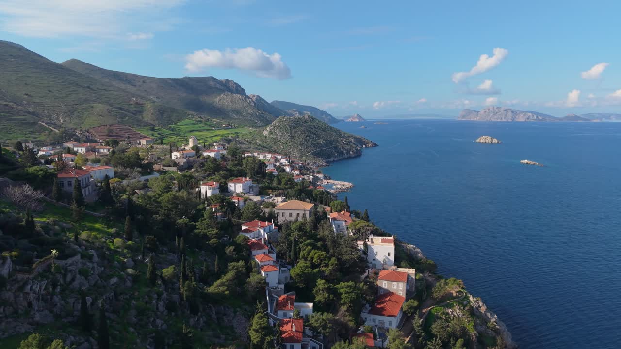 Aerial drone footage of the charming port of Kaminia on Hydra, Greece. Traditional houses, fishing boats, and a unique coastal backdrop full of island character