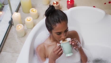 mixed race woman lying in a bathtub at home