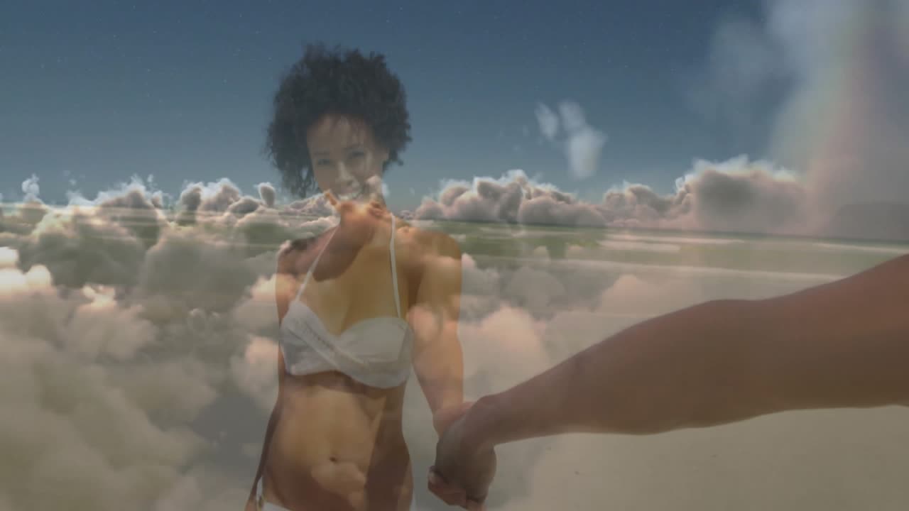Nuvens flutuando, mulher de biquíni branco de mãos dadas com o parceiro, guiando-o pela praia para uma viagem.