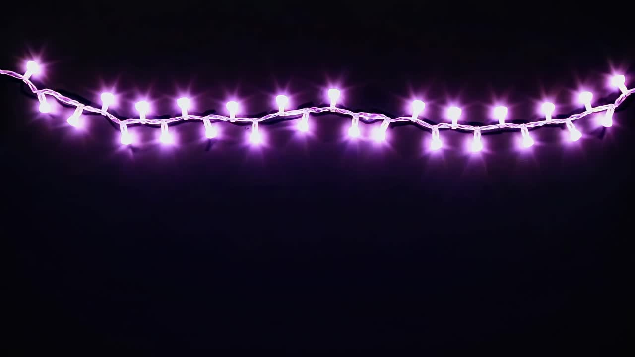 A string of glowing lights against a dark background, captured from a low angle