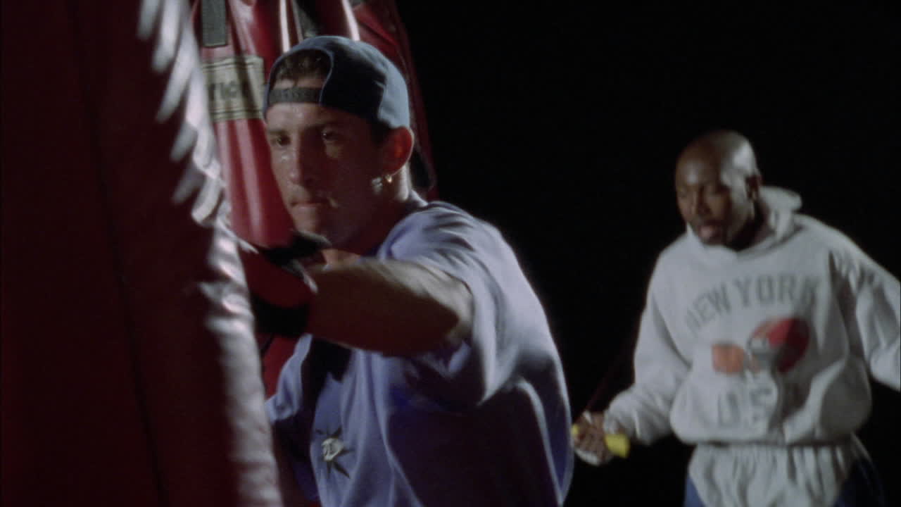 dos boxeadores, uno saltando la cuerda y el otro trabajando en un saco de boxeo