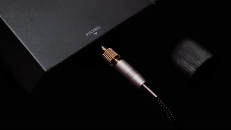 a man's hand plugging the headphone jack into an electronic keyboard, musical instrument