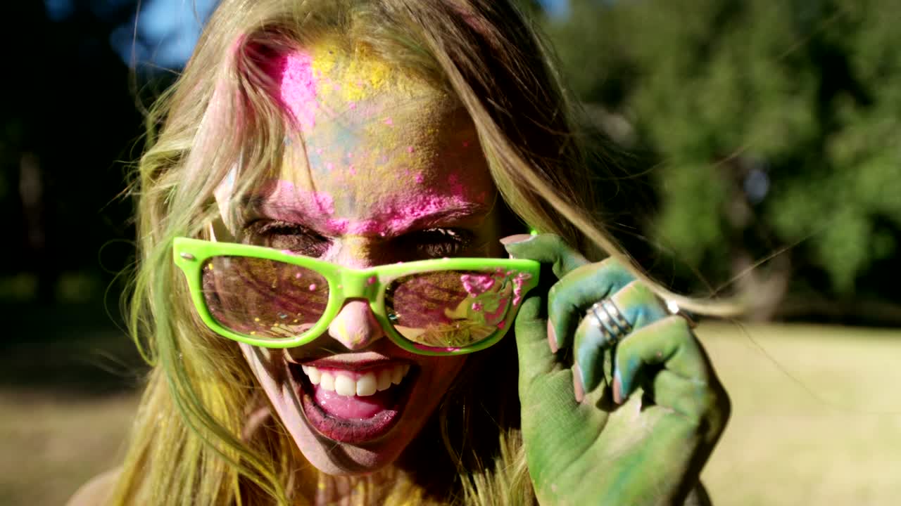 Primo piano del viso di una ragazza coperta di polvere Holi.
