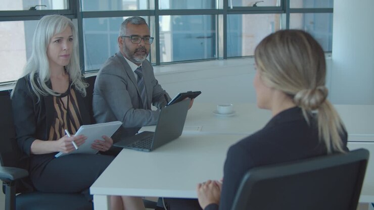 Young business woman talking to employer and HR manager