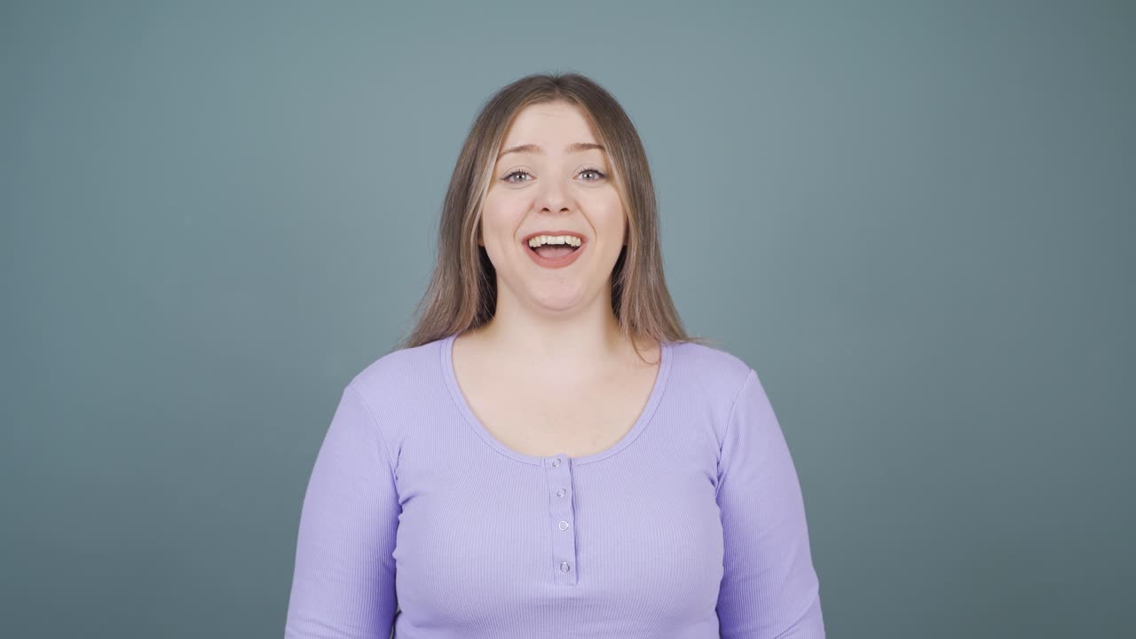 젊은 여성은 카메라에 "와우"라고 말합니다.