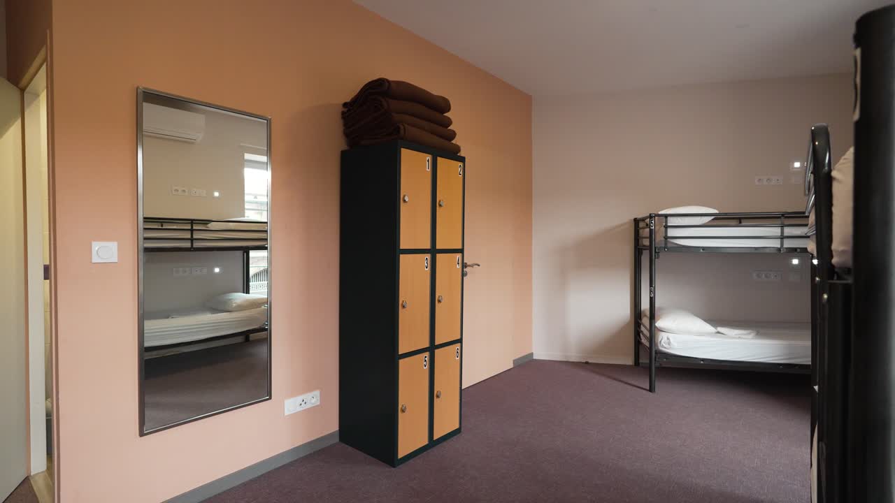 dormitorio de un albergue juvenil con armario, mantas y litera