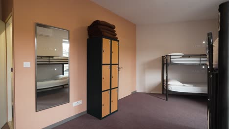 dormitorio de un albergue juvenil con armario, mantas y litera