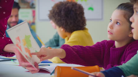 close up of female student looking at map in classroom geography lesson