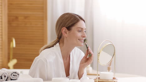 woman applying eye skincare product with a tool in the bathroom